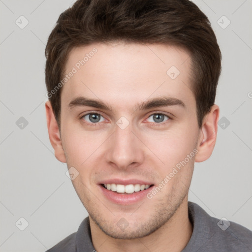 Joyful white young-adult male with short  brown hair and grey eyes