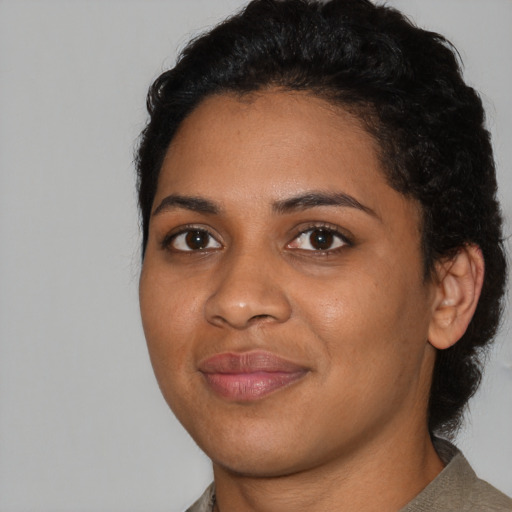 Joyful black young-adult female with short  black hair and brown eyes