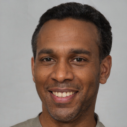 Joyful latino adult male with short  black hair and brown eyes