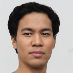 Joyful asian young-adult male with short  black hair and brown eyes