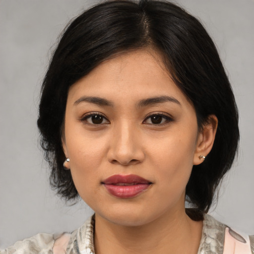 Joyful asian young-adult female with medium  brown hair and brown eyes