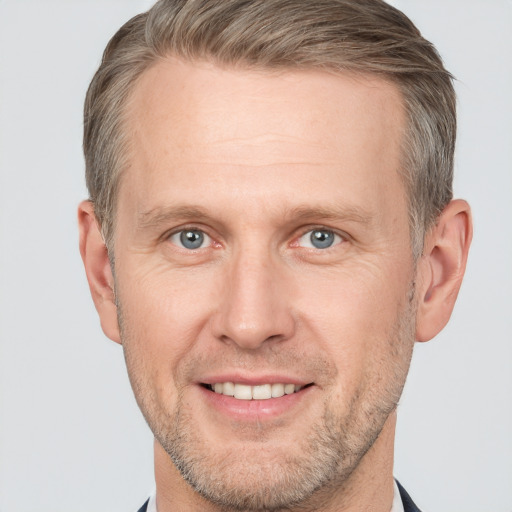 Joyful white adult male with short  brown hair and grey eyes