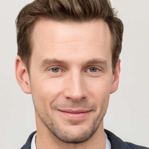 Joyful white young-adult male with short  brown hair and grey eyes