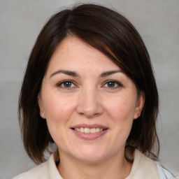 Joyful white adult female with medium  brown hair and brown eyes