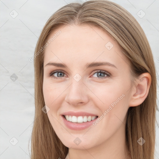 Joyful white young-adult female with long  brown hair and blue eyes