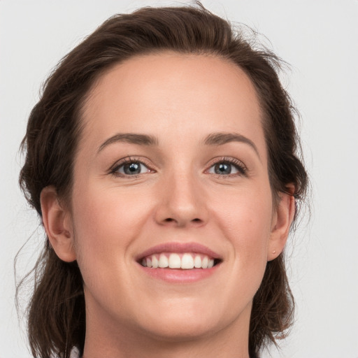 Joyful white young-adult female with long  brown hair and grey eyes