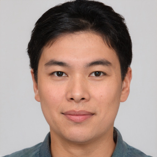 Joyful asian young-adult male with short  brown hair and brown eyes