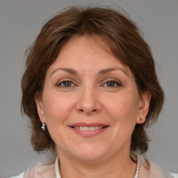 Joyful white adult female with medium  brown hair and grey eyes