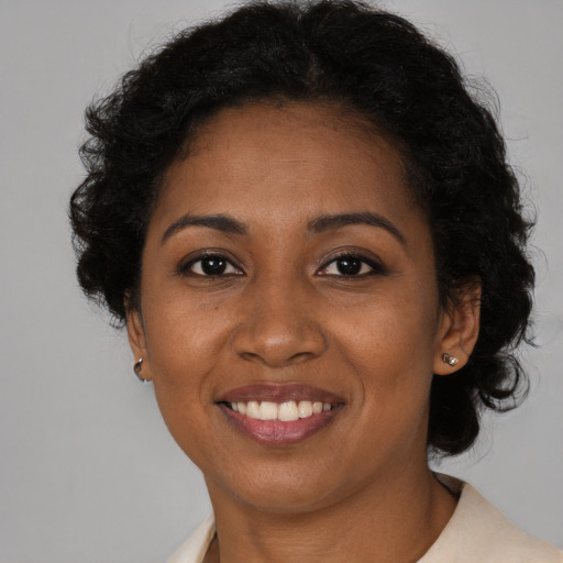 Joyful black young-adult female with short  black hair and brown eyes