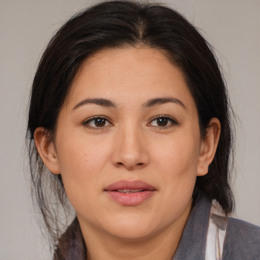 Joyful latino young-adult female with medium  brown hair and brown eyes