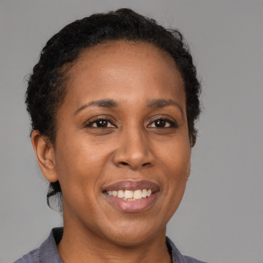 Joyful black young-adult female with short  brown hair and brown eyes