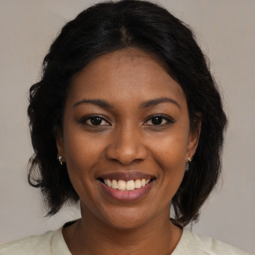 Joyful black young-adult female with medium  brown hair and brown eyes