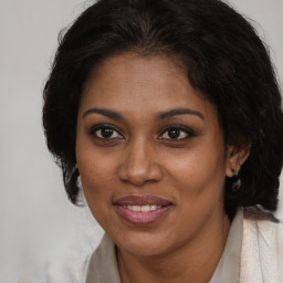 Joyful black young-adult female with medium  brown hair and brown eyes