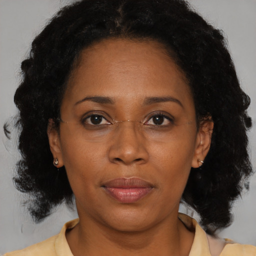 Joyful black adult female with medium  brown hair and brown eyes