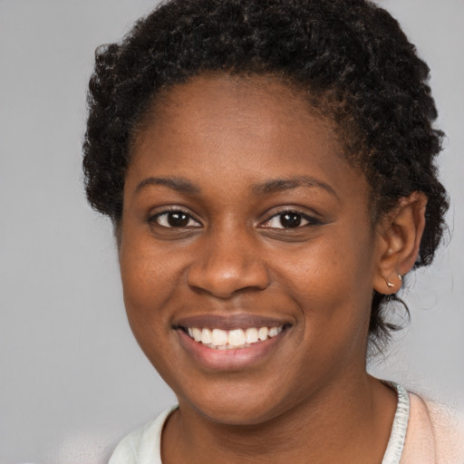 Joyful black young-adult female with short  brown hair and brown eyes