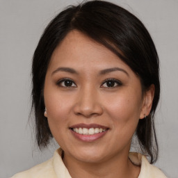 Joyful asian young-adult female with medium  brown hair and brown eyes