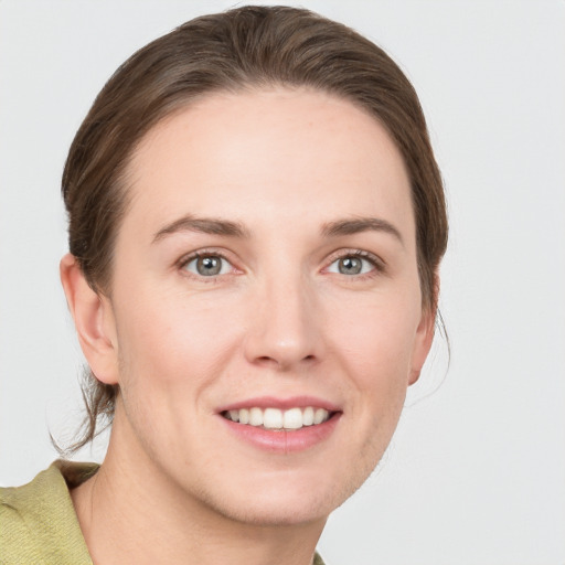 Joyful white young-adult female with medium  brown hair and grey eyes