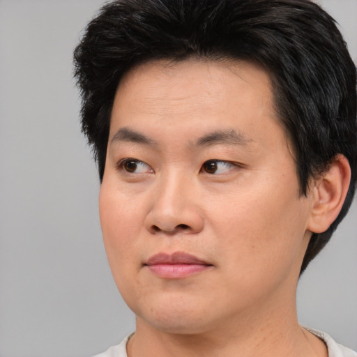Joyful asian young-adult male with short  brown hair and brown eyes