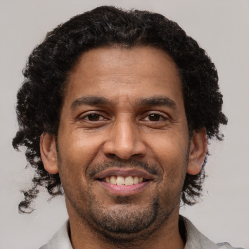 Joyful black adult male with short  brown hair and brown eyes