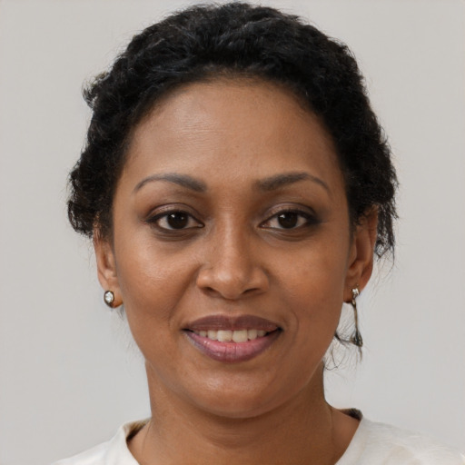Joyful black adult female with short  brown hair and brown eyes