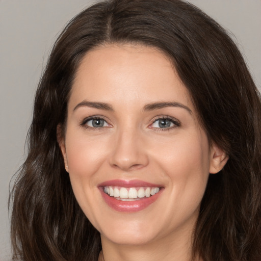 Joyful white young-adult female with long  brown hair and brown eyes