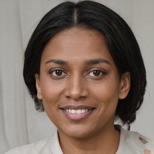 Joyful black young-adult female with medium  brown hair and brown eyes