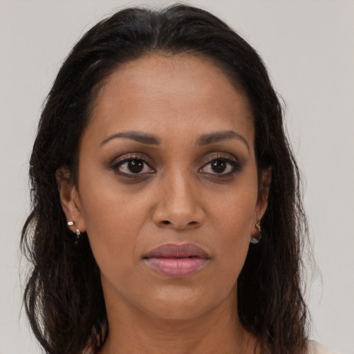 Joyful black young-adult female with long  brown hair and brown eyes