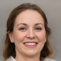 Joyful white adult female with medium  brown hair and grey eyes