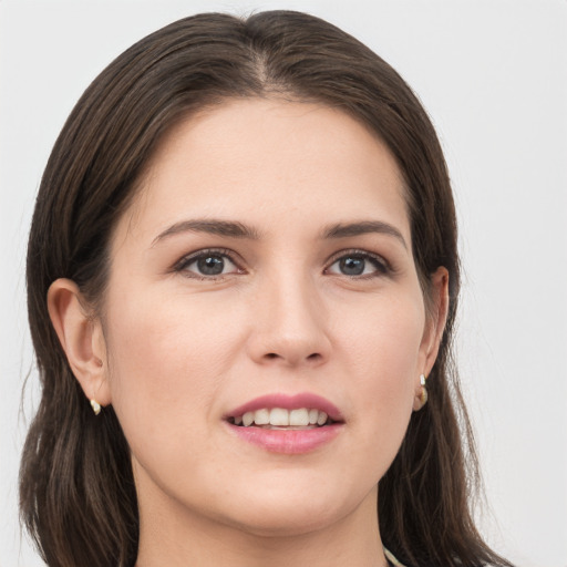 Joyful white young-adult female with long  brown hair and grey eyes