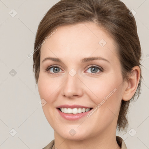 Joyful white young-adult female with medium  brown hair and grey eyes