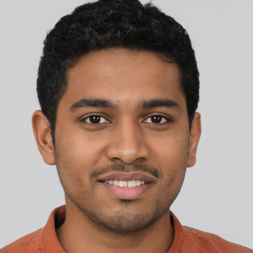 Joyful latino young-adult male with short  black hair and brown eyes