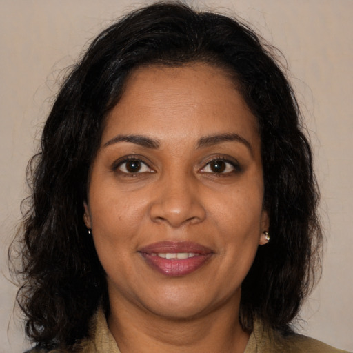Joyful black adult female with medium  brown hair and brown eyes
