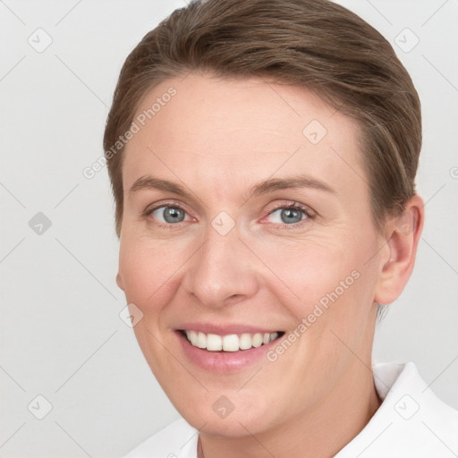 Joyful white young-adult female with short  brown hair and grey eyes