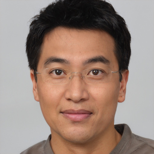 Joyful asian young-adult male with short  black hair and brown eyes