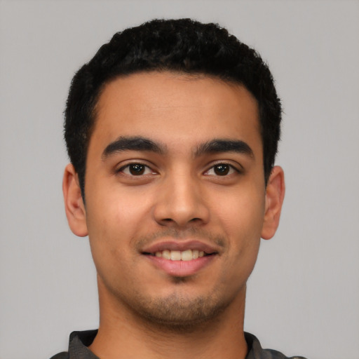 Joyful latino young-adult male with short  black hair and brown eyes