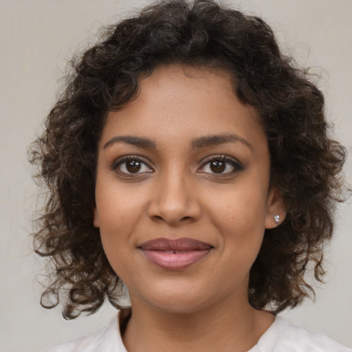 Joyful black young-adult female with medium  brown hair and brown eyes