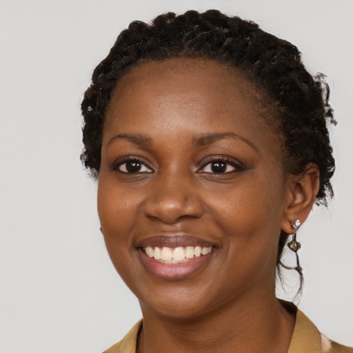 Joyful black young-adult female with short  brown hair and brown eyes
