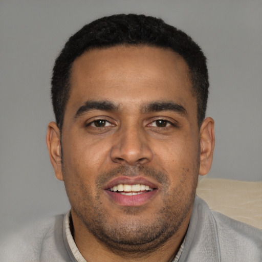 Joyful black young-adult male with short  black hair and brown eyes