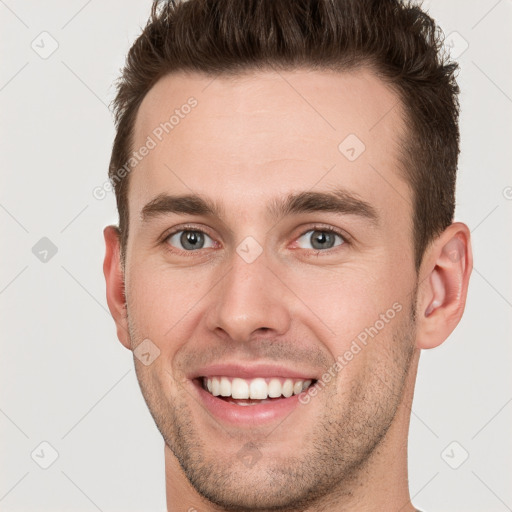 Joyful white young-adult male with short  brown hair and grey eyes