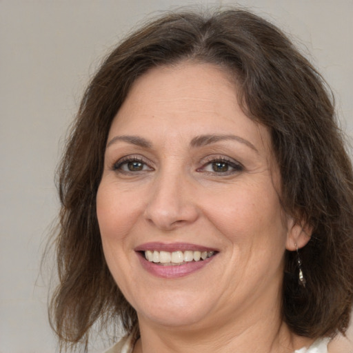 Joyful white adult female with medium  brown hair and brown eyes