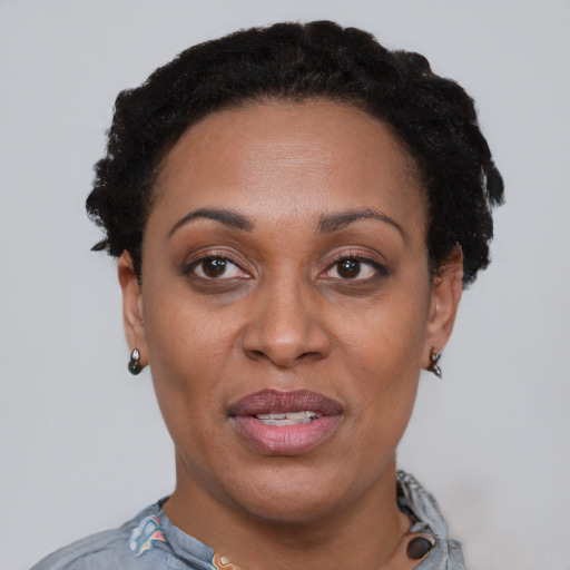 Joyful black adult female with short  black hair and brown eyes