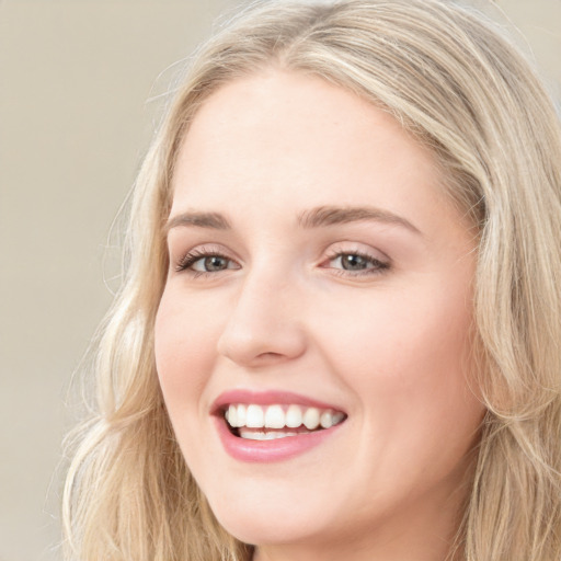 Joyful white young-adult female with long  brown hair and blue eyes