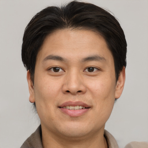 Joyful asian young-adult male with short  brown hair and brown eyes