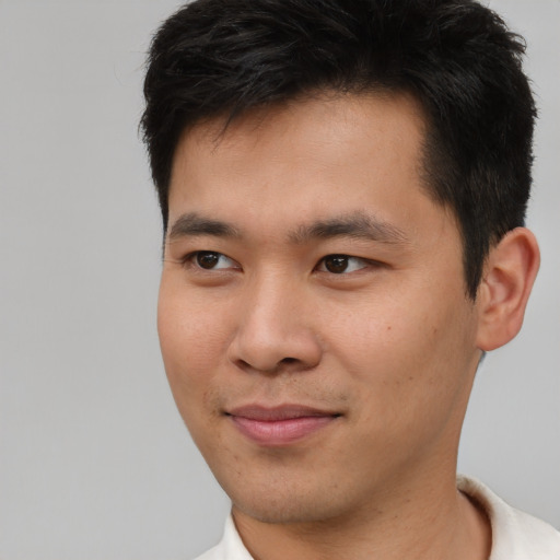 Joyful asian young-adult male with short  brown hair and brown eyes