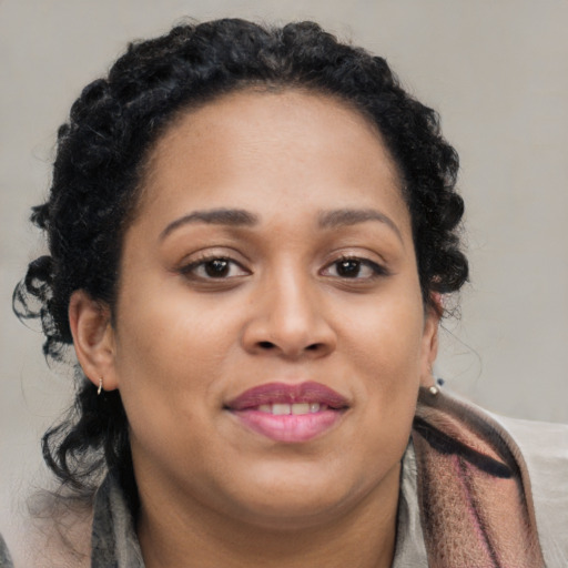 Joyful black young-adult female with long  brown hair and brown eyes