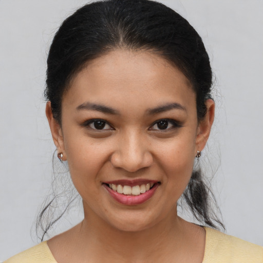 Joyful latino young-adult female with medium  brown hair and brown eyes