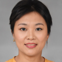 Joyful asian young-adult female with short  brown hair and brown eyes