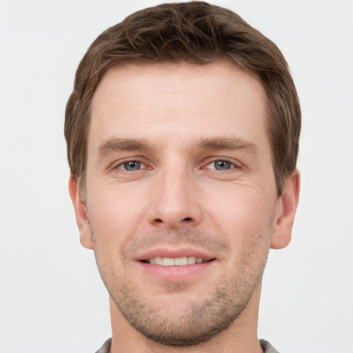 Joyful white young-adult male with short  brown hair and grey eyes