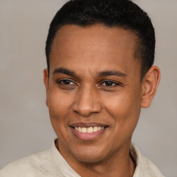 Joyful latino young-adult male with short  brown hair and brown eyes