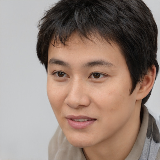 Joyful asian young-adult male with short  brown hair and brown eyes